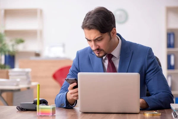 Empleado joven sentado en el lugar de trabajo —  Fotos de Stock