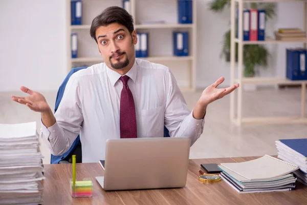 Junge männliche Mitarbeiter und zu viel Arbeit im Büro — Stockfoto