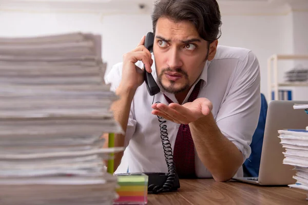 Jeune employé masculin et trop de travail au bureau — Photo