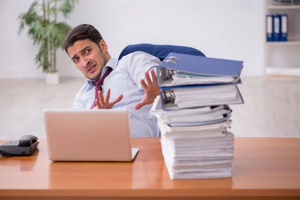 Joven hombre de negocios y demasiado trabajo en la oficina — Foto de Stock