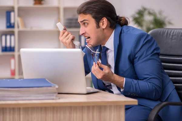 Jonge mannelijke werknemer op kantoor — Stockfoto