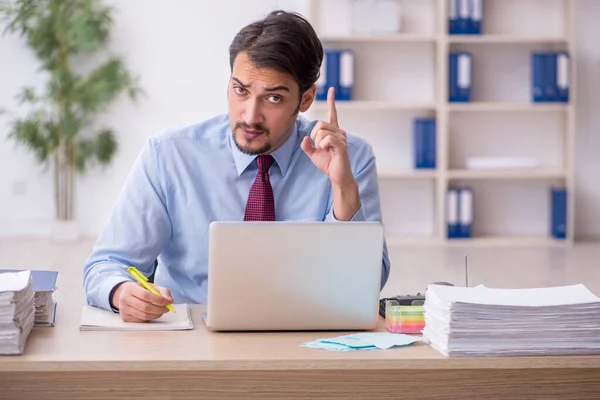 Jeune employé masculin et trop de travail au bureau — Photo