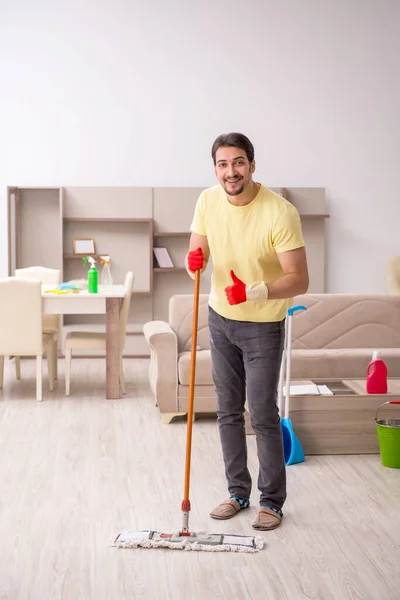 Jonge mannelijke aannemer schoonmaken van het huis — Stockfoto