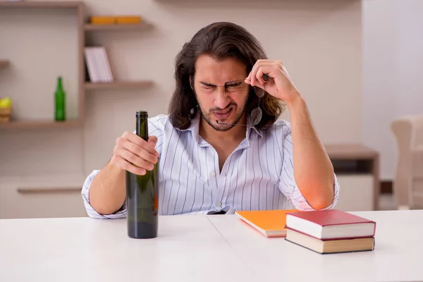 Young male student drinking alcohol at home — Stock Photo, Image