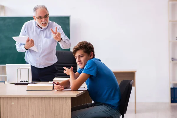 Öreg férfi tanár és iskolás fiú az osztályteremben — Stock Fotó