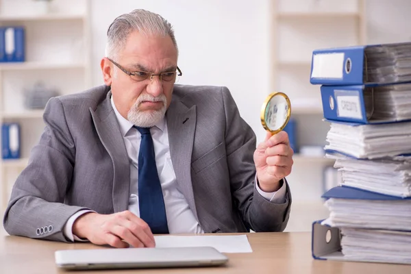 Oude mannelijke werknemer ongelukkig met overmatig werk in het kantoor — Stockfoto