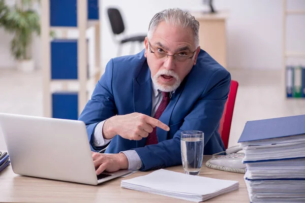 Oude mannelijke werknemer en te veel werk op kantoor — Stockfoto