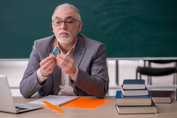 Homem velho professor químico na frente de quadro negro — Fotografia de Stock