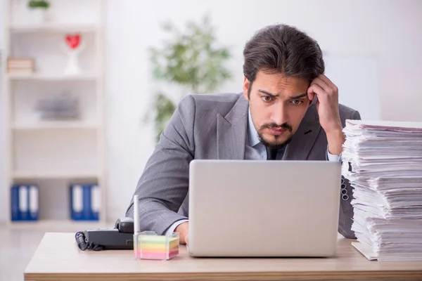 Giovane dipendente maschio e troppo lavoro in ufficio — Foto Stock