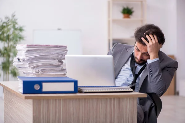 Jeune employé masculin et trop de travail au bureau — Photo