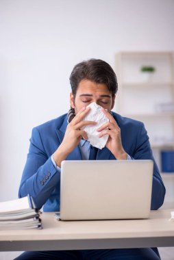 İş yerinde acı çeken genç bir erkek işçi.