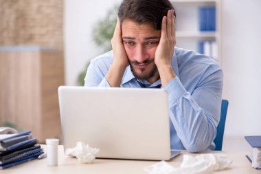 İş yerinde acı çeken genç bir erkek işçi.