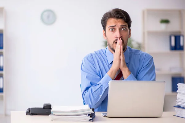 Junge männliche Angestellte unzufrieden mit exzessiver Arbeit im Büro — Stockfoto