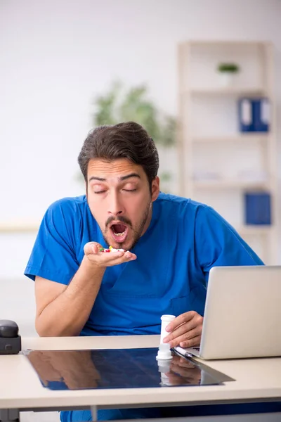 Young male doctor suffering in the clinic — Stock Photo, Image