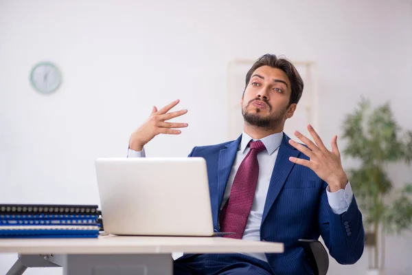 Young male employee unhappy with excessive work in the office — Stock Photo, Image