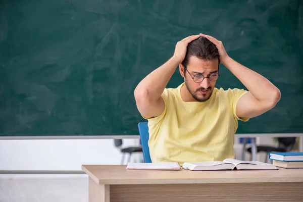 Jovem estudante se preparando para exames em sala de aula — Fotografia de Stock