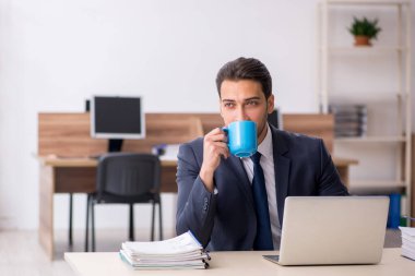 Molada kahve içen genç bir erkek.