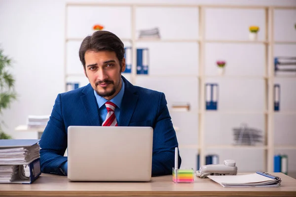 Jovem trabalhador masculino sentado no local de trabalho — Fotografia de Stock