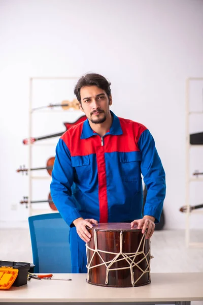 Fiatal férfi szerelő hangszereket javít a munkahelyen — Stock Fotó