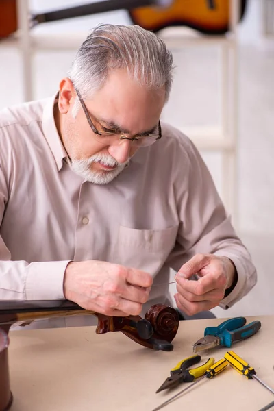 Бывший мастер по ремонту музыкальных инструментов на работе — стоковое фото