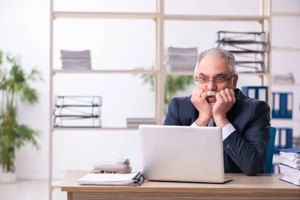 Vecchio dipendente maschio infelice con il lavoro eccessivo in ufficio — Foto Stock