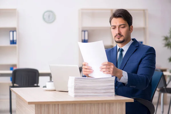 Junge männliche Mitarbeiter und zu viel Arbeit im Büro — Stockfoto