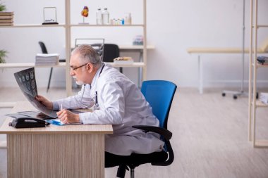 Klinikte çalışan yaşlı bir erkek radyolog.