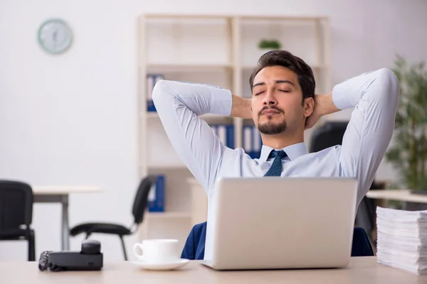 Jovem funcionário masculino infeliz com excesso de trabalho no escritório — Fotografia de Stock