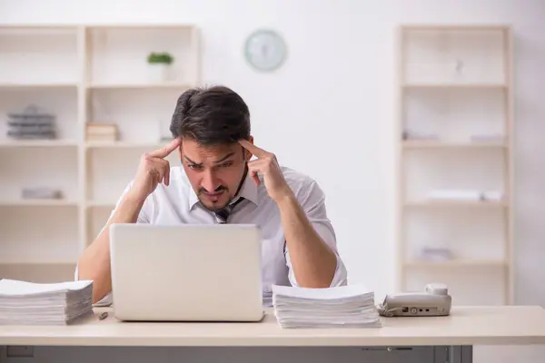 Jovem funcionário masculino infeliz com excesso de trabalho no escritório — Fotografia de Stock