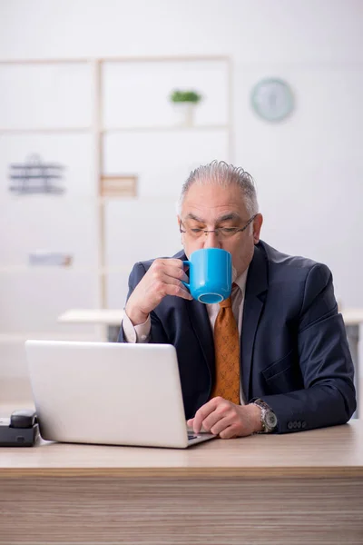 Alte männliche Angestellte trinkt Kaffee in der Pause — Stockfoto