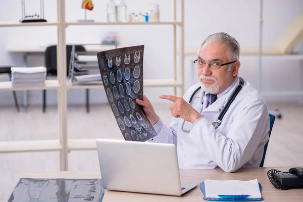 Gammal manlig röntgenläkare som arbetar på kliniken — Stockfoto