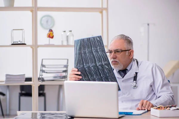 Klinikte çalışan yaşlı bir erkek radyolog. — Stok fotoğraf