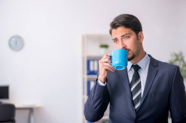 Molada kahve içen genç bir erkek.