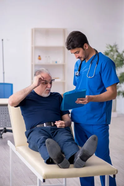 Yaşlı adam genç erkek doktoru ziyaret ediyor. — Stok fotoğraf