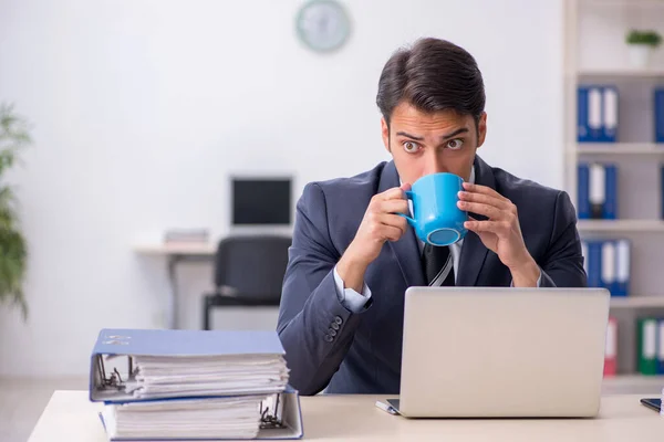 Mladý muž zaměstnanec pije kávu během přestávky — Stock fotografie