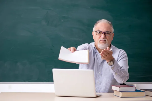 Viejo profesor delante del tablero verde — Foto de Stock