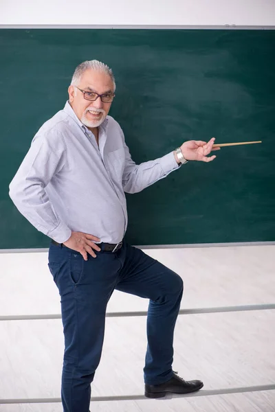 Alter männlicher Lehrer vor grünem Brett — Stockfoto