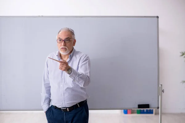 Velho professor masculino na frente do quadro branco — Fotografia de Stock