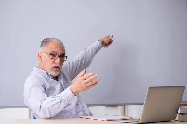 화이트보드 앞에 서 있는 늙은 남성 교사 — 스톡 사진