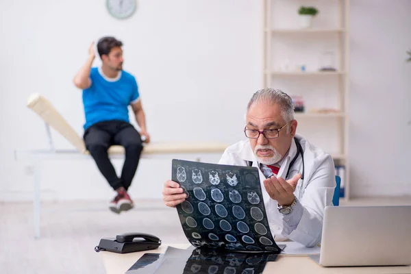 Paciente masculino joven que visita al radiólogo médico anciano —  Fotos de Stock