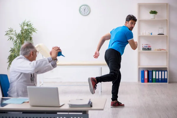 Jovem paciente masculino visitando velho médico gastroenterologista masculino — Fotografia de Stock