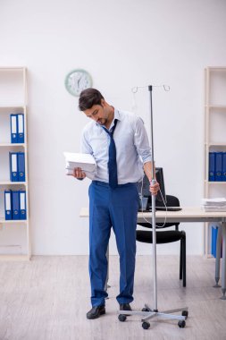 İş yerinde acı çeken genç bir erkek işçi.