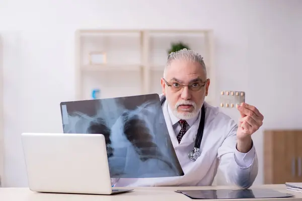 Gammal manlig röntgenläkare som arbetar på kliniken — Stockfoto