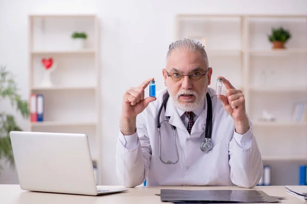 Gammal manlig läkare som arbetar på kliniken — Stockfoto