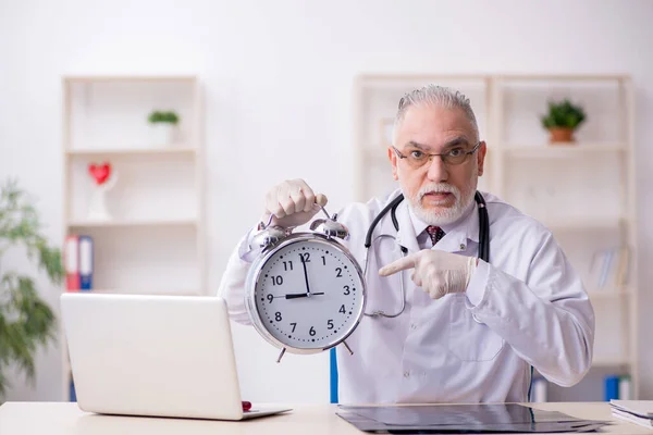 Old male doctor in time management concept — Stock Photo, Image