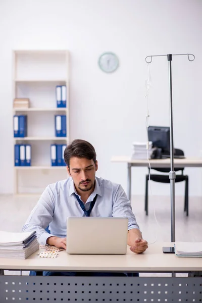 Young male employee suffering at workplace — Stock Photo, Image