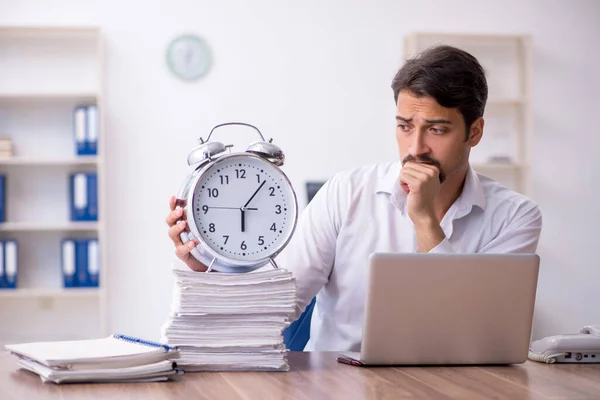 Joven empleado masculino en concepto de gestión del tiempo — Foto de Stock