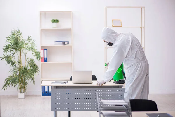 Un tânăr antreprenor dezinfectează biroul în timpul pandemiei — Fotografie, imagine de stoc