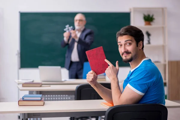 古い男性物理の先生と若い男性学生の前で黒 — ストック写真