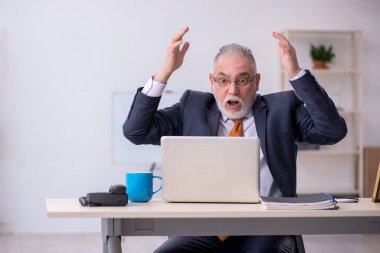 Ofiste çalışan yaşlı bir erkek.